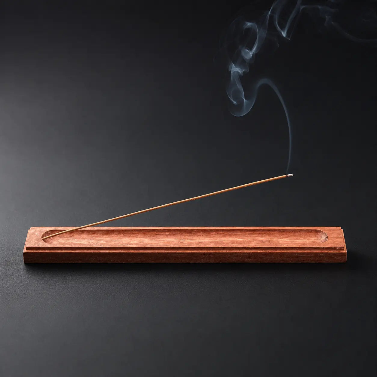 Rosewood incense holder with burning incense stick for peaceful aromatherapy rituals