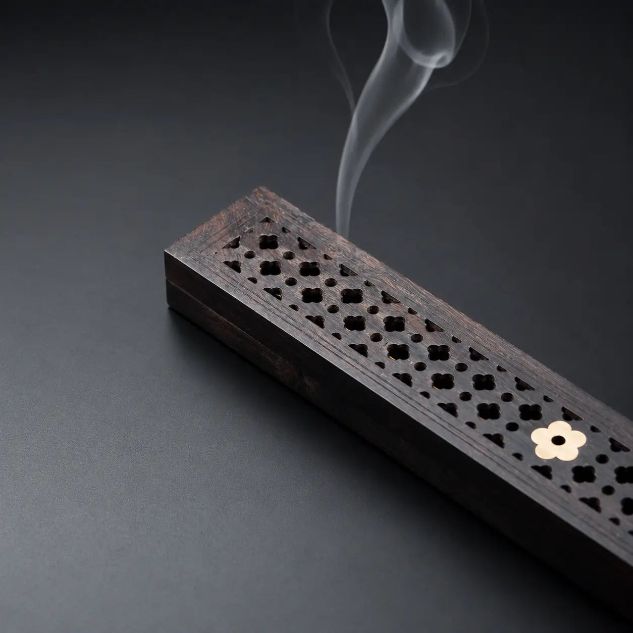 Hand holding an ebony incense box for elegant incense storage and aromatherapy use