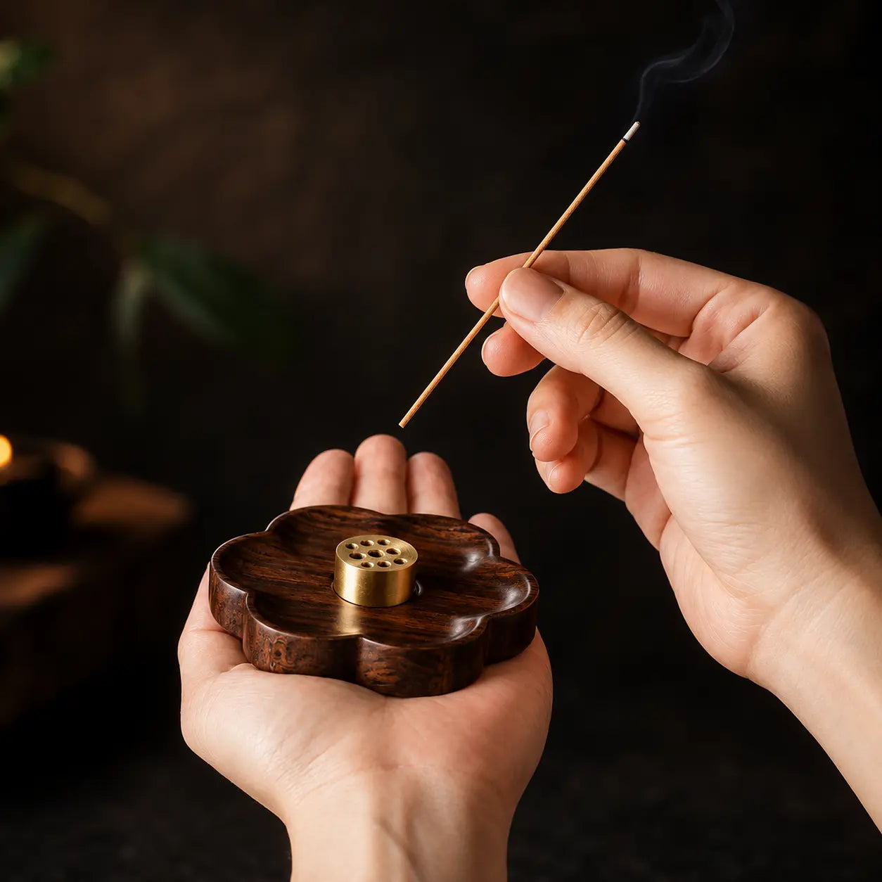 Hand holding a sakura wooden incense holder for a mindful incense burning ritual